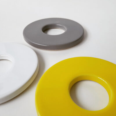 Close up of doughnut shaped coasters in white, grey and yellow.