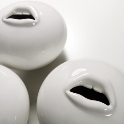 Oval bud vase with opening in shape of lips with teeth.
