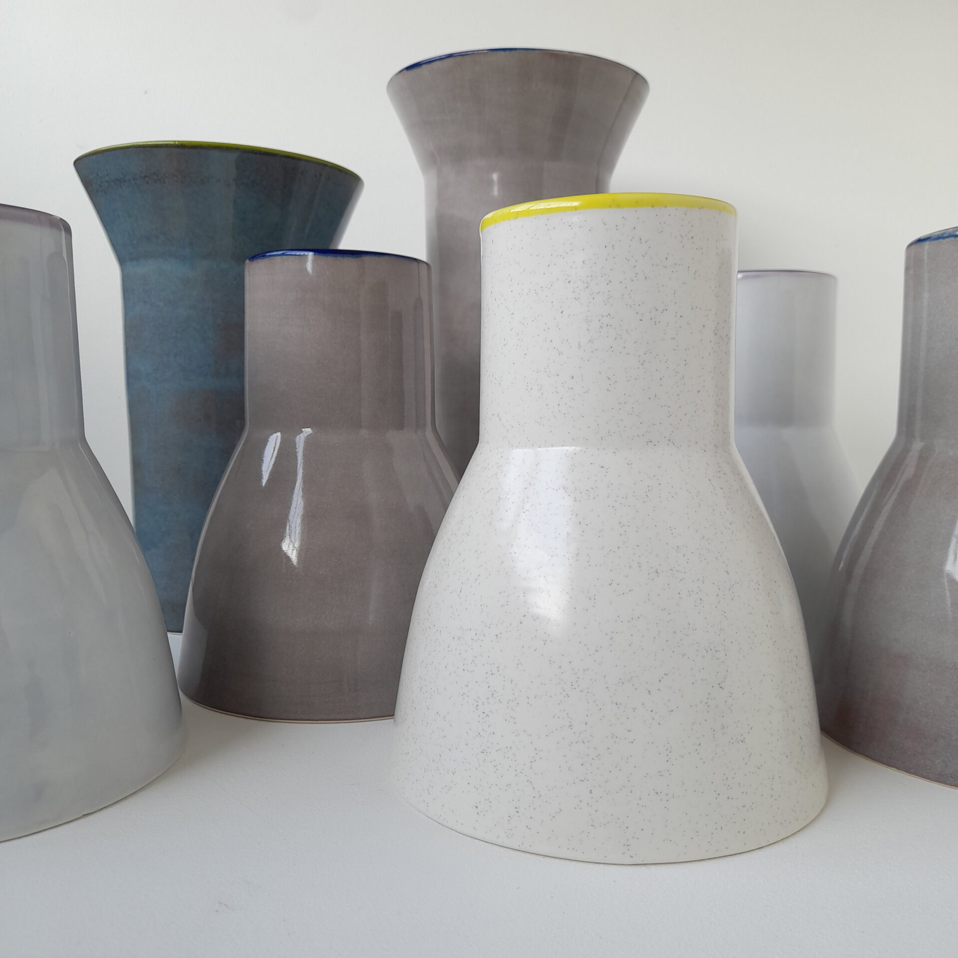 Collection of flower vases in pale grey, cream and blue.