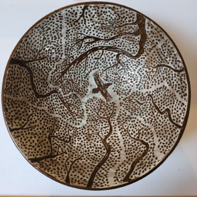 a bowl showing a raven flying through the treetops