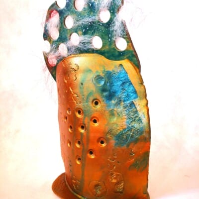 "Scandal" is a vessel of whispered truths and shouted defiance. Adorned with doll’s hair and an oxidized glaze that recalls the corroded surface of an old speaker, this pot embodies the transmission of gossip, myth, and suppressed histories. The tangled hair suggests the entrapment of voices—stories spun, distorted, and controlled—while the speaker-like form hints at both amplification and censorship. Scandal interrogates the power structures that dictate who get to speak and who is silenced, transforming the pot into an artifact of resistance, where the echoes of past and present voices refuse to be contained.